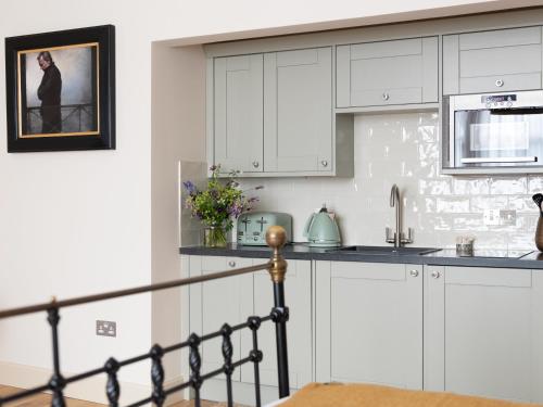 a kitchen with white cabinets and a sink at Running Hare - Uk7558 in Inverness