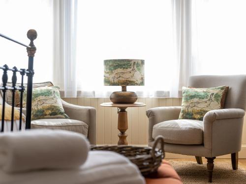 a living room with two chairs and a lamp at Running Hare - Uk7558 in Inverness