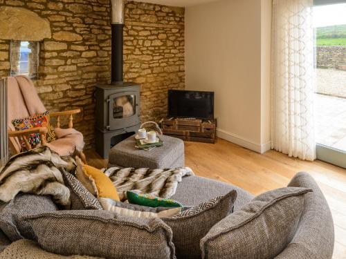 a living room with a couch and a wood stove at Barn End - Uk32694 in Horton