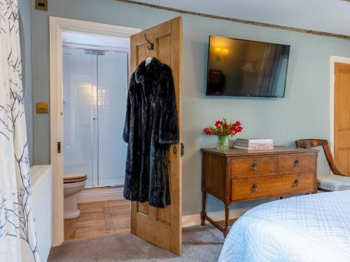 a bedroom with a robe hanging on a door at Auchengool House in Kirkcudbright