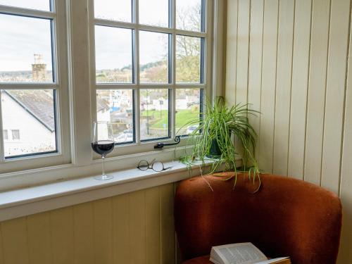 a window sill with a glass of wine and a chair at Auchengool House in Kirkcudbright