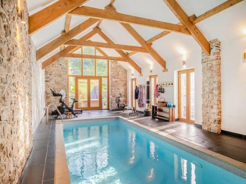 an indoor pool in a house with wooden beams at Y-Beudy Bach - Uk51421 in Llandeilo