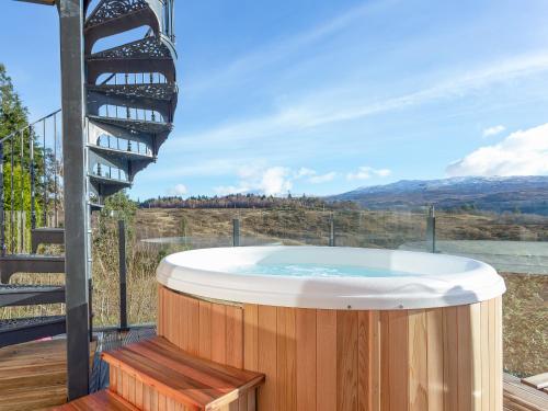 a jacuzzi tub on a deck with a staircase at Jill Strawbale House- Ukc2935 in Strontian