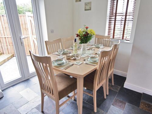 a dining room table with chairs and flowers on it at Ty Ffynnon - Hw7601 in Llansantffraid