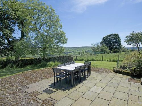 a table and chairs sitting on a stone patio at Dale House in Castleton