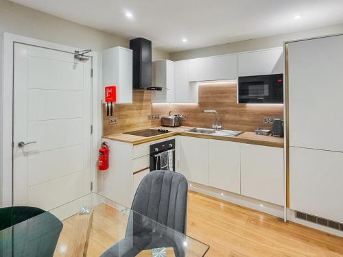 a kitchen with white cabinets and a glass table at Uk47852 - No 1B in Aberystwyth