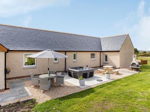 a backyard with a barbecue grill and a house at Morven View in Dunbeath