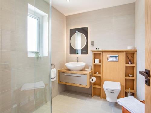 a bathroom with a sink and a toilet and a mirror at Morven View in Dunbeath