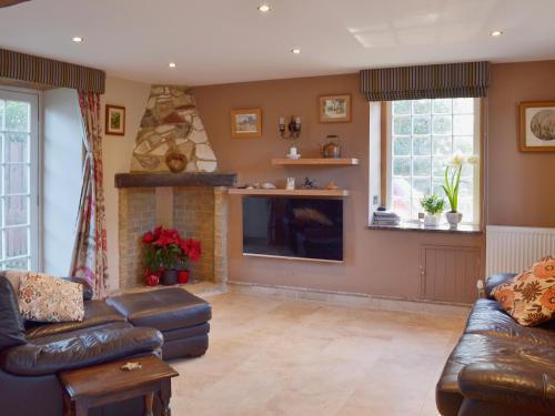 a living room with a couch and a fireplace at Brixton Barn in Mottistone