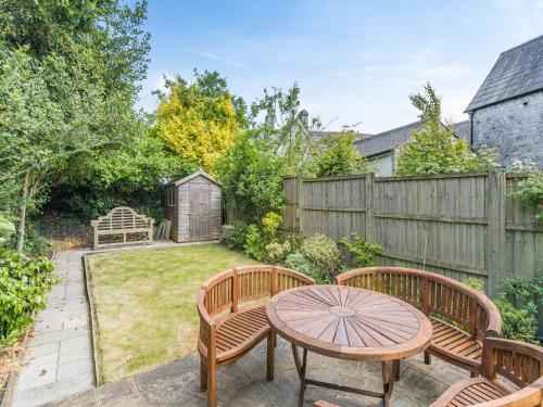 a backyard with two wooden benches and a table at Barngarth in Cartmel