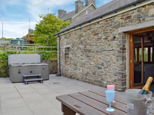a patio with a wooden table and a brick building at Caffi Sali - Weluk143 in Blaenpenal