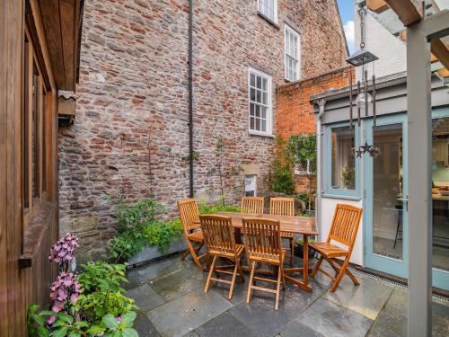a patio with a wooden table and chairs at Rock House in Wells