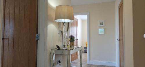a hallway with a table and a lamp at Cozy 2BR apartment in Maidenhead Sleeps 6 in Maidenhead