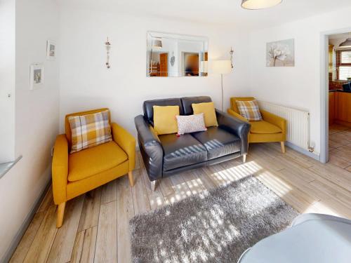 a living room with two chairs and a couch at Elm Cottage-Uk2791 in Penmaen-mawr