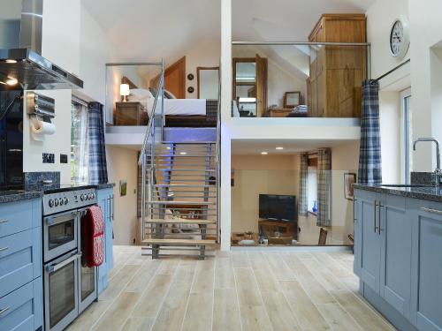 a kitchen with blue cabinets and a bunk bed at Bluebell Barn in Okehampton