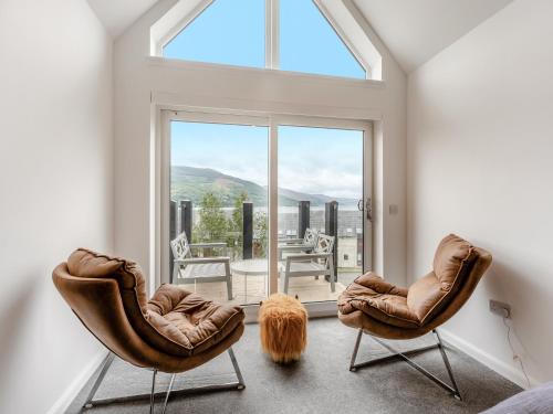 a room with two chairs and a large window at Shoreside in Aberfeldy