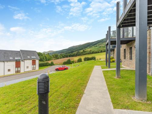 a building with a car parked on the side of a road at Shoreside in Aberfeldy