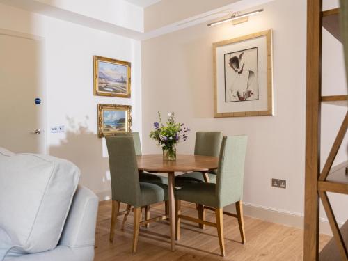 a dining room with a wooden table and chairs at Courtyard - Uk7554 in Inverness
