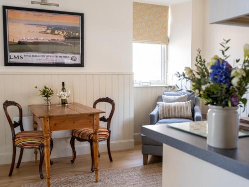 a kitchen and living room with a wooden table and chairs at Courtyard - Uk7554 in Inverness