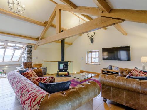 a living room with leather furniture and a fireplace at Mungeon Barn - Uk30125 in Backbarrow