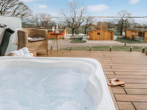 a bath tub sitting on a deck with a patio at Elmore - Uk51111 in Clitheroe