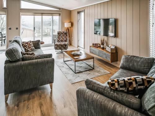 a living room with two couches and a table at Elmore - Uk51111 in Clitheroe