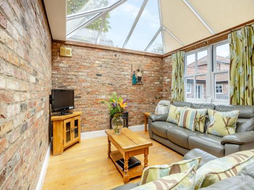 a living room with a couch and a tv at The Stables - Uk47151 in Burgh le Marsh