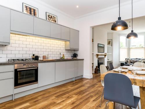 a kitchen with white cabinets and a table with chairs at Priory Street in York