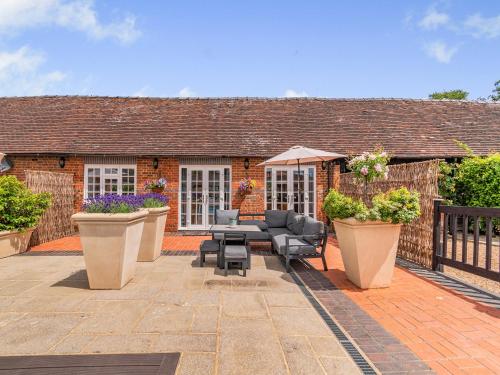 a patio with furniture and plants in front of a house at The Pool House - Uk49372 in Send