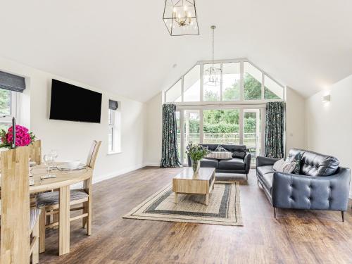 a living room with a table and a dining room at Kings Lodge in Neatishead