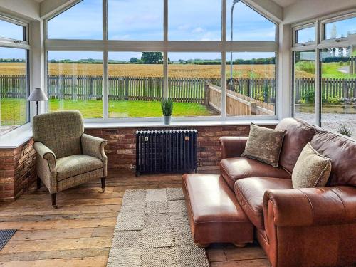 a living room with a couch and chairs and windows at Normandy in Wyberton
