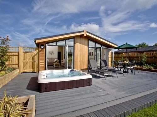 a large deck with a hot tub on it at Holly Lodge in Hassocks