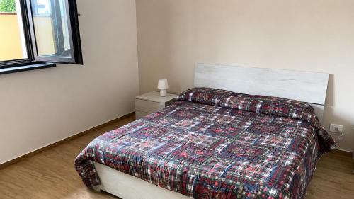 a bedroom with a bed with a blanket on it at Casa RUDOM in Aci SantʼAntonio