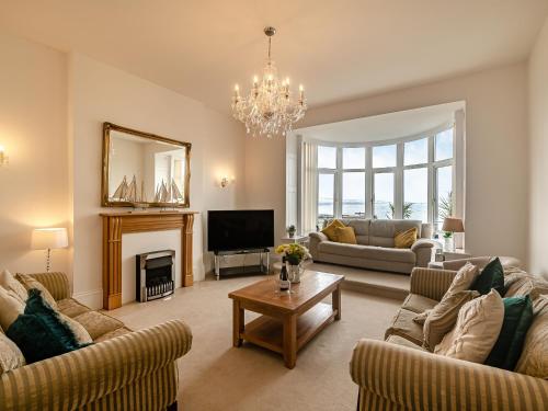 a living room with two couches and a fireplace at Babbacombe House in Torquay