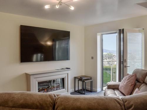 a living room with a couch and a fireplace at Kinneret Apartment in Silsden