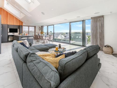 a living room with a gray couch and a table at Seabreeze in Saint Mawes