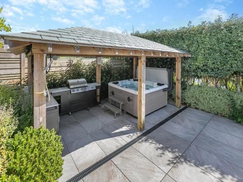 a gazebo with a hot tub and a grill at Seabreeze in Saint Mawes