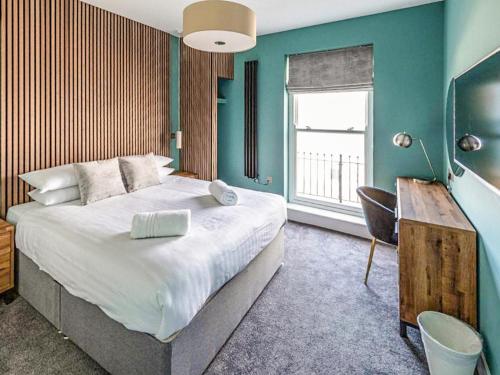 a bedroom with a large bed with a desk and a window at Uk47853 - No 2B in Aberystwyth