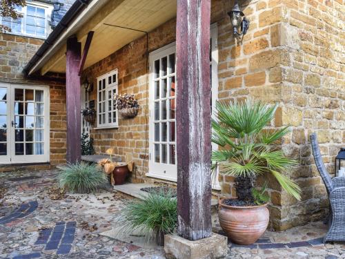 a brick house with potted plants and a pole at Russell Cottage in Flore