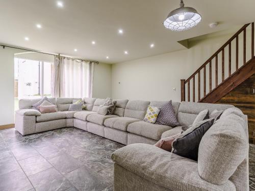 a living room with a couch and a staircase at The Millhouse - Uk32510 in Marloes