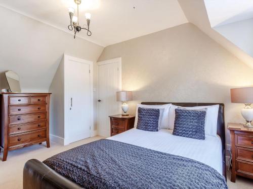 a bedroom with a bed and a dresser and lamps at Willow Cottage - Uk39244 in Inverness