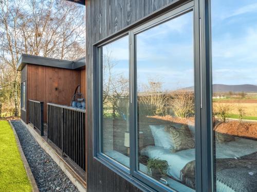 a screened in porch with a couch and a window at Hayloft - Uk49529 in Buchlyvie