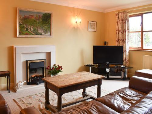 a living room with a couch and a tv at The Palm in Seasalter