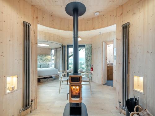 a wood burning stove in a room with a bedroom at The Treehouse Caerlaverock - Uk45028 in Carsethorn