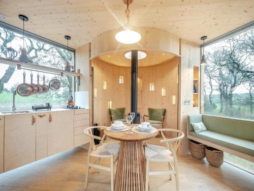 a kitchen and dining room with a table and chairs at The Treehouse Caerlaverock - Uk45028 in Carsethorn