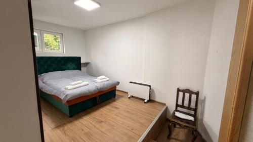 a small bedroom with a bed and a wooden floor at Baklava in Sarajevo