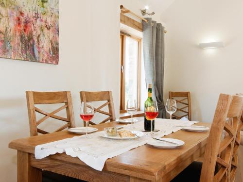 a wooden table with glasses of wine and food on it at Meadow Barn - Blackdown Farm in Blackawton