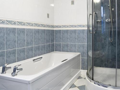 a white bath tub in a bathroom with a shower at Ysgubor in Harlech