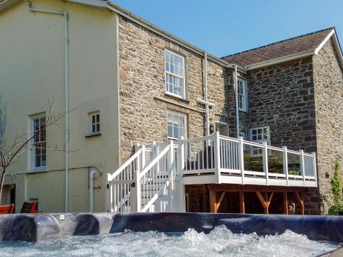 a house with a white deck and a building at Awelfa - On7 in Aberaeron
