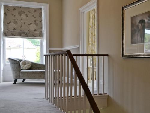 a staircase in a house with a chair and a window at Awelfa - On7 in Aberaeron